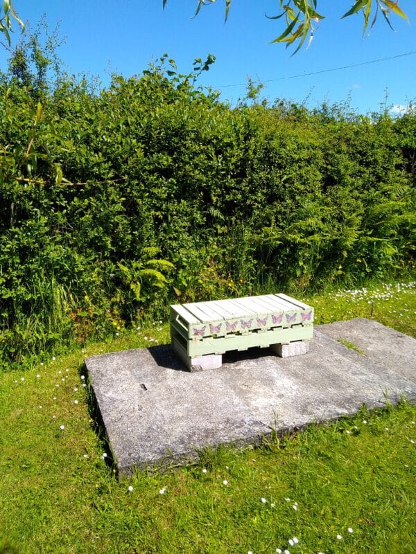 A two-person garden seat made from a cut, painted and decorated pallet. llet